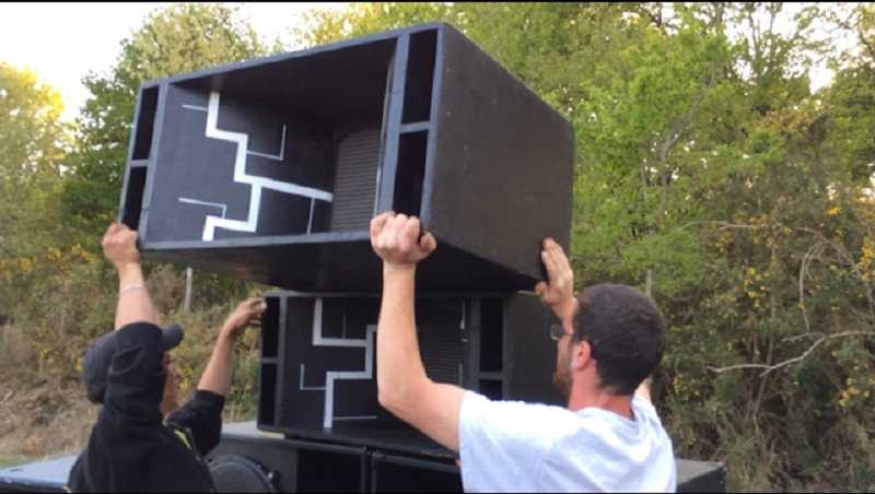 Montage d’un mur de son tekno en extérieur avec plusieurs caissons empilés